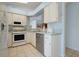 Functional kitchen with white cabinetry and appliances, tile flooring, and a bright interior at 26736 Cash Ct, Leesburg, FL 34748