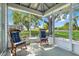 Cozy screened-in patio with comfortable seating and a beautiful view of the landscaped backyard at 26736 Cash Ct, Leesburg, FL 34748