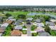 Aerial view showcasing homes surrounding a pristine golf course and a tranquil pond in a desirable community at 3049 Saint Thomas Ln, The Villages, FL 32162