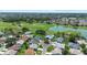 An aerial view captures a lush, green golf course, a serene pond and beautiful residences within a community at 3049 Saint Thomas Ln, The Villages, FL 32162