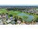 Lush green golf course and a serene pond surround the beautiful residences within a vibrant community in this aerial view at 3049 Saint Thomas Ln, The Villages, FL 32162