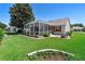 Beautiful backyard with screened-in patio, manicured lawn, and lovely landscaping at 3049 Saint Thomas Ln, The Villages, FL 32162