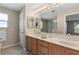 Bathroom featuring double sinks, modern vanity, and a well-lit mirror for added convenience at 3049 Saint Thomas Ln, The Villages, FL 32162