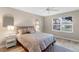Cozy bedroom with natural light, ceiling fan, and modern accent mirrors and geometric rug at 3049 Saint Thomas Ln, The Villages, FL 32162