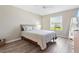 Bright bedroom with a large window, wood-look floors, and neutral tones creates a serene space at 3049 Saint Thomas Ln, The Villages, FL 32162