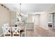 Inviting dining area features a round wood table with white chairs and modern light fixture at 3049 Saint Thomas Ln, The Villages, FL 32162
