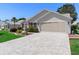 Single Gathering home featuring an extra long brick driveway and two car garage at 3049 Saint Thomas Ln, The Villages, FL 32162