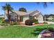 Inviting single-Gathering home with a well-kept lawn, garden beds, and red window shutters at 3049 Saint Thomas Ln, The Villages, FL 32162