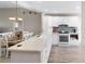 Open kitchen with a light countertop breakfast bar, stainless appliances, and white cabinets at 3049 Saint Thomas Ln, The Villages, FL 32162