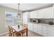 Eat-in kitchen features white cabinets, stainless microwave, and natural light from the large window at 3049 Saint Thomas Ln, The Villages, FL 32162