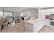 Open floor plan featuring the living room with the kitchen and dining area in the background at 3049 Saint Thomas Ln, The Villages, FL 32162