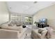 Comfortable living room with vaulted ceiling, neutral decor, and sliding glass doors to patio at 3049 Saint Thomas Ln, The Villages, FL 32162