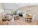 Spacious living room featuring wood-look floors, a dining table, and access to the screened patio at 3049 Saint Thomas Ln, The Villages, FL 32162