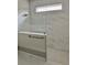 A modern glass-enclosed shower featuring marble tile and a built-in niche at 3070 Sunscape Ter, Groveland, FL 34736