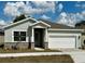 Charming single-story home featuring stone accents, neutral colors, and a well-manicured lawn at 3070 Sunscape Ter, Groveland, FL 34736