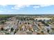 Sprawling aerial view of a residential community featuring tree-lined streets, homes, and a serene lake at 312 Emmalee Pl, The Villages, FL 32162