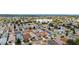 Aerial view showcases a residential neighborhood with diverse home styles, lush greenery, and a scenic lake at 312 Emmalee Pl, The Villages, FL 32162