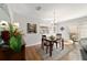 Sunlit dining area featuring wood floors and a decorative chandelier at 312 Emmalee Pl, The Villages, FL 32162