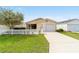 Charming single-story home featuring a well-manicured lawn, white picket fence, and an attached one-car garage at 312 Emmalee Pl, The Villages, FL 32162