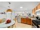 Bright kitchen offering wood cabinets, modern appliances, and openness to the living and dining areas at 312 Emmalee Pl, The Villages, FL 32162