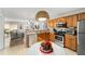 Well-equipped kitchen featuring wood cabinets and stainless steel appliances open to the cozy living space at 312 Emmalee Pl, The Villages, FL 32162