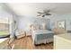 Bright main bedroom featuring an overhead fan, wood look floors, and comfortable seating at 312 Emmalee Pl, The Villages, FL 32162