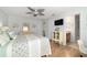 Inviting main bedroom featuring a decorative ceiling fan, wood look floors, and an en suite bathroom at 312 Emmalee Pl, The Villages, FL 32162