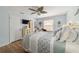 Comfortable main bedroom with a decorative ceiling fan, wood look floors, and abundant natural light at 312 Emmalee Pl, The Villages, FL 32162