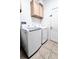 Bright laundry room with modern washer and dryer, cabinet storage, and tiled floors at 326 Crystal Pond Ave, Deland, FL 32720