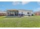 Backyard featuring a covered patio with outdoor furniture, spacious yard with ample space for recreational activities at 3329 Boyd Cir, Oxford, FL 34484