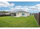 Expansive backyard features lush green lawn, screened lanai, and concrete patio for outdoor living and entertaining at 3329 Boyd Cir, Oxford, FL 34484