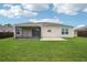 The spacious backyard boasts a screened lanai, lush lawn, and a brown privacy fence at 3329 Boyd Cir, Oxford, FL 34484
