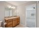 Bathroom featuring wood cabinets, granite countertops, and a walk-in shower at 3329 Boyd Cir, Oxford, FL 34484