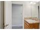 Bathroom featuring wood cabinets, granite counters, sink, and a door leading to another room at 3329 Boyd Cir, Oxford, FL 34484