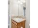 Bright bathroom with an updated vanity with a granite countertop, decorative pulls, and a large mirror at 3329 Boyd Cir, Oxford, FL 34484