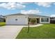 Inviting single-level home with a two-car garage, tidy lawn, and attractive landscaping details at 3329 Boyd Cir, Oxford, FL 34484