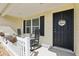 Cozy front porch features rocking chairs and a decorative welcome sign on the front door at 3329 Boyd Cir, Oxford, FL 34484