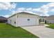 Close-up of a two-car garage showcasing ample parking space and an adjacent landscaped yard at 3329 Boyd Cir, Oxford, FL 34484