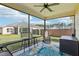 Inviting screened-in patio with comfortable seating, ceiling fan, and views of the lush backyard at 3329 Boyd Cir, Oxford, FL 34484