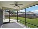 View of the screened patio and lush green backyard, enclosed by a brown fence at 3329 Boyd Cir, Oxford, FL 34484