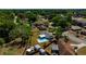Aerial shot of a single-story home with a screened-in pool and fenced yard in a tree-lined neighborhood at 3415 Sail Fish Ave, Fruitland Park, FL 34731