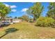 Expansive backyard featuring a well-maintained lawn, white picket fence, storage shed, and a partially covered patio at 3415 Sail Fish Ave, Fruitland Park, FL 34731