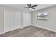 A bright bedroom with wood-look flooring features a ceiling fan and double closets at 3415 Sail Fish Ave, Fruitland Park, FL 34731
