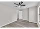 Neutrally painted bedroom showcasing wood-look floors and a ceiling fan and white door at 3415 Sail Fish Ave, Fruitland Park, FL 34731
