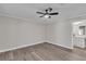 Bright bedroom with a ceiling fan, wood-look flooring, and a view leading to the bathroom at 3415 Sail Fish Ave, Fruitland Park, FL 34731