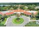 Aerial view of clubhouse featuring a circular driveway, lush landscaping, and tile roof at 3603 Westerham Dr, Clermont, FL 34711