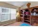 Well-lit den with vaulted ceiling, hardwood floors, a large window and custom wood shelving at 3603 Westerham Dr, Clermont, FL 34711