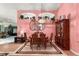 Dining area with pink walls, laminate floors, and dining table, adjacent to the living room at 3603 Westerham Dr, Clermont, FL 34711