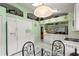Kitchen features white appliances, tile floors, and a glass top dining table with four wrought iron chairs at 3603 Westerham Dr, Clermont, FL 34711