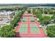 Aerial shot of multiple tennis courts surrounded by trees and landscaping at 3603 Westerham Dr, Clermont, FL 34711